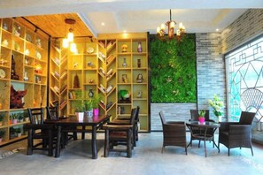 A room with a dining area, bookshelves, and a green wall. - Jinyatai Holiday Manor (Hengyang)
