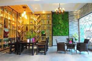 A room with a dining area, bookshelves, and a green wall.