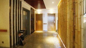 A hallway with a wooden ceiling, a bamboo wall, and a patterned floor. - Jinyatai Holiday Manor (Hengyang)