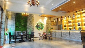 A modern interior with a reception desk, seating area, and decorative wall art. - Jinyatai Holiday Manor (Hengyang)