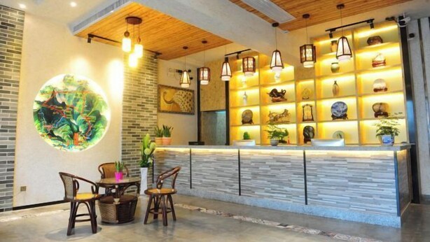 A reception area with a stone counter, wooden ceiling, and hanging pendant lights. - Jinyatai Holiday Manor (Hengyang)