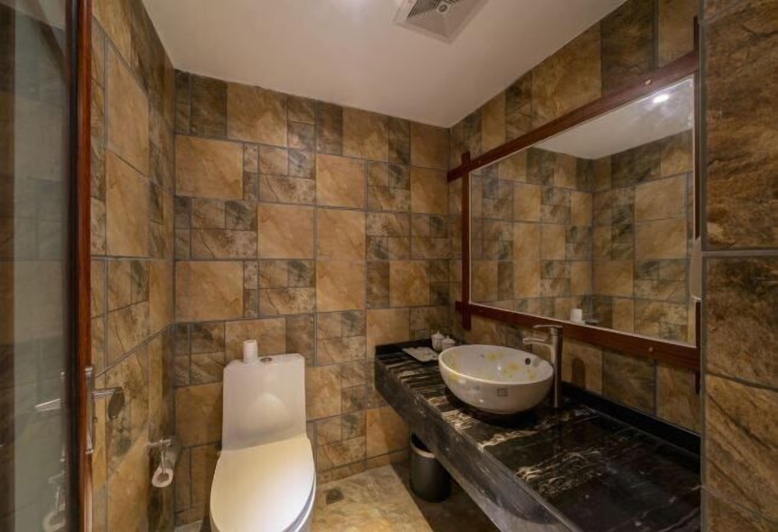Un baño con inodoro, lavamanos y espejo.