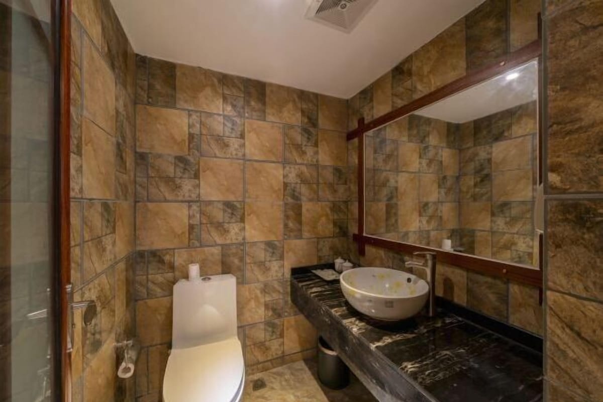 A bathroom with a toilet, a sink with a basin, and a mirror.
