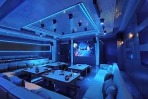 Un interior moderno con un sofá modular, una televisión de pantalla plana e iluminación ambiental.