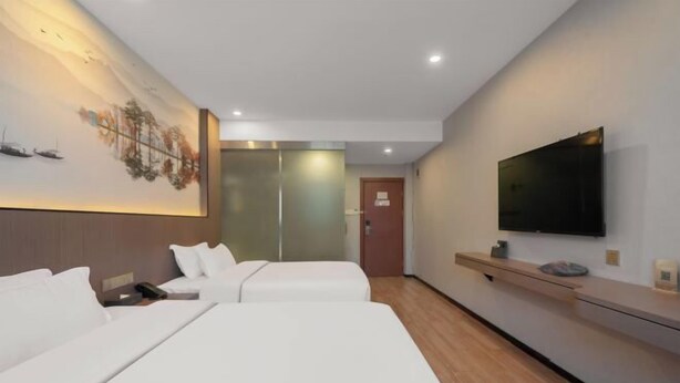 A hotel room with two beds, a large painting on the wall, a TV mounted on the wall, and a wooden floor. - Four Seasons Jun'an Hotel (Fuzhou Jinshan Subway Station Branch) (Fuzhou)