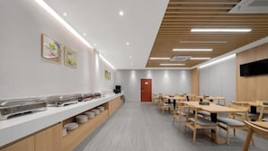 A modern cafeteria with a long counter, wooden tables, and chairs. - Four Seasons Jun'an Hotel (Fuzhou Jinshan Subway Station Branch) (Fuzhou)