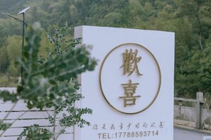 A sign with Chinese characters and a contact number. - Huanxi Homestay (Hangzhou)