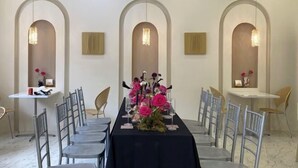 A dining area with a long table, chairs, and decorative flowers. - Huanxi Homestay (Hangzhou)