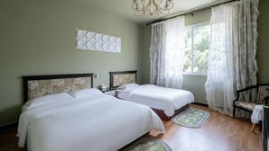 A room with two beds, a chandelier, a window with sheer curtains, and a chair. - Huanxi Homestay (Hangzhou)