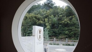 A circular window view of a building with a sign that reads "Hotel". - Huanxi Homestay (Hangzhou)