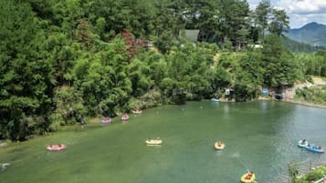 Un río con varias lanchas inflables y un área boscosa al fondo.