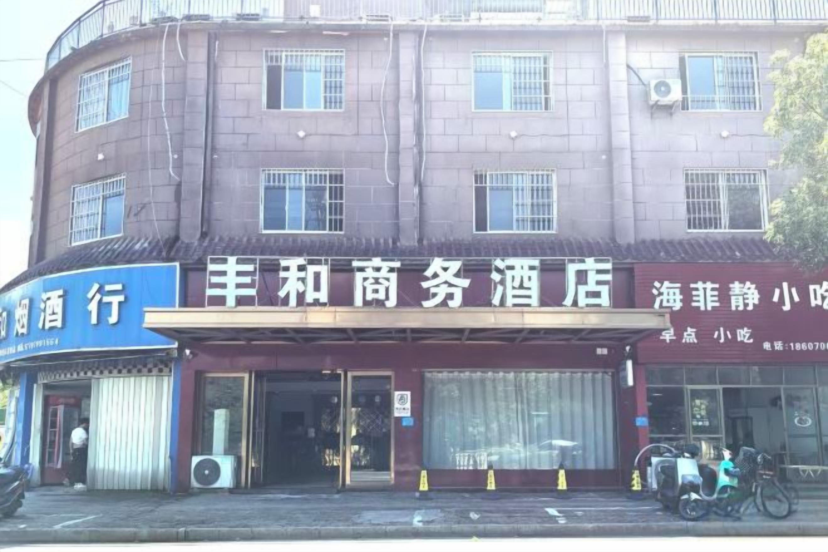 Un edificio con varios comercios en la planta baja, entre ellos un hotel y una licorería.