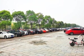 Um parque de estacionamento com vários carros e uma bicicleta.