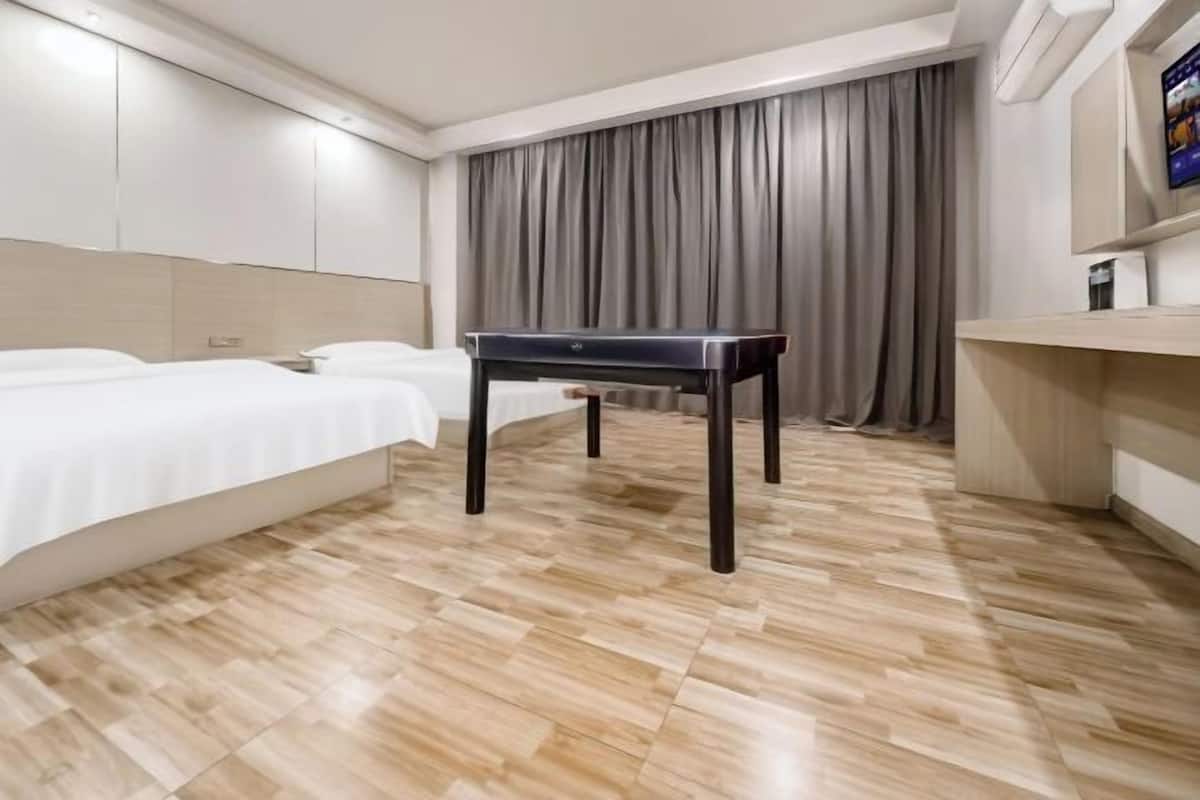 A hotel room with a bed, a desk, and a TV.