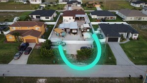An aerial view of a residential area with houses, a driveway, and a curved pathway. - Casita Bella Beautiful Cottage IN Wonderful Cape Coral FL. Come Enjoy! (Cape Coral)
