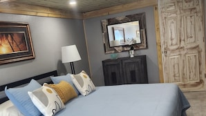 A bedroom with a bed, pillows, a nightstand, a lamp, a mirror, and a wardrobe. - Casita Bella Beautiful Cottage IN Wonderful Cape Coral FL. Come Enjoy! (Cape Coral)