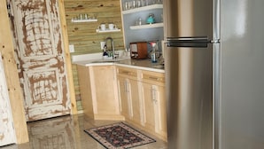 A modern kitchen with a stainless steel refrigerator, wooden ceiling, and tiled floor. - Casita Bella Beautiful Cottage IN Wonderful Cape Coral FL. Come Enjoy! (Cape Coral)