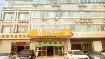 A hotel with a prominent sign for China Inn, multiple parked cars, and a building facade with air conditioning units.