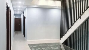 A hallway with a glass floor, a staircase with black railings, and a door at the end. - Lujiang Business and Trade City Hotel (Rongjiang)
