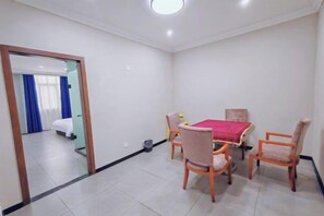 Une chambre d’hôtel équipée d’une table à manger, de quatre chaises, d’un lit et d’un miroir.