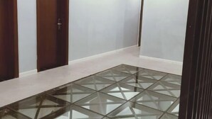 A hallway with a glass-topped table and wooden doors. - Lujiang Business and Trade City Hotel (Rongjiang)