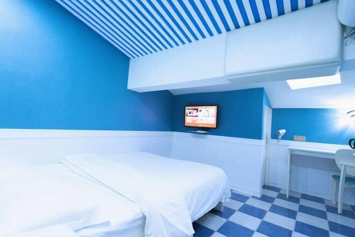 A room with a bed, a desk, and a television.