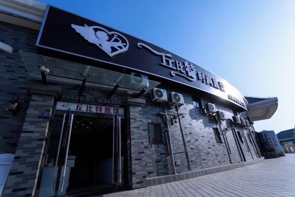A building with a sign that reads '五比特旅馆' and a sign below it that says '五比特旅馆'.