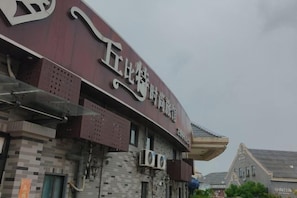 A building with a large sign and a sloped roof. - Cupid Fashion Inn Yancheng (Fortune Port of Preschool Normal University) (Yancheng)
