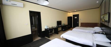 Een hotelkamer met twee bedden, een bureau, een stoel, een televisie en een airconditioning.
