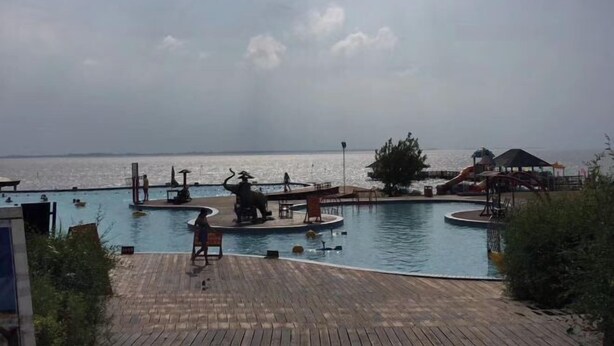 A wooden deck with a pool, a slide, and a view of the sea. - Tai 9 Hotel (duelbert) (Dorbod County)