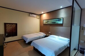 A hotel room with two single beds, a wall-mounted air conditioner, a framed artwork, and a small table with a chair. - Tai 9 Hotel (duelbert) (Dorbod County)