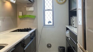 Una cocina compacta con estufa a gas, microondas y refrigerador.