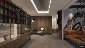A modern living room with a wooden reception desk, a sofa, and a wall with a graphic design.