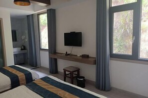 Een hotelkamer met een bed, een bureau, een televisie en een raam.