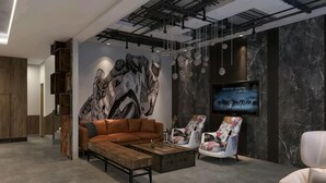 A modern living room with a sectional sofa, a coffee table, a TV, and a mural on the wall.