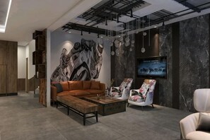 A modern living room with a sectional sofa, a coffee table, a TV, and a mural on the wall.
