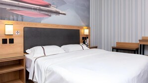 A hotel room with a bed, a nightstand, a wall-mounted lamp, and a mural of a mountain landscape. - Thank You Inn Beijing Huairou Yanqi (Huairou)