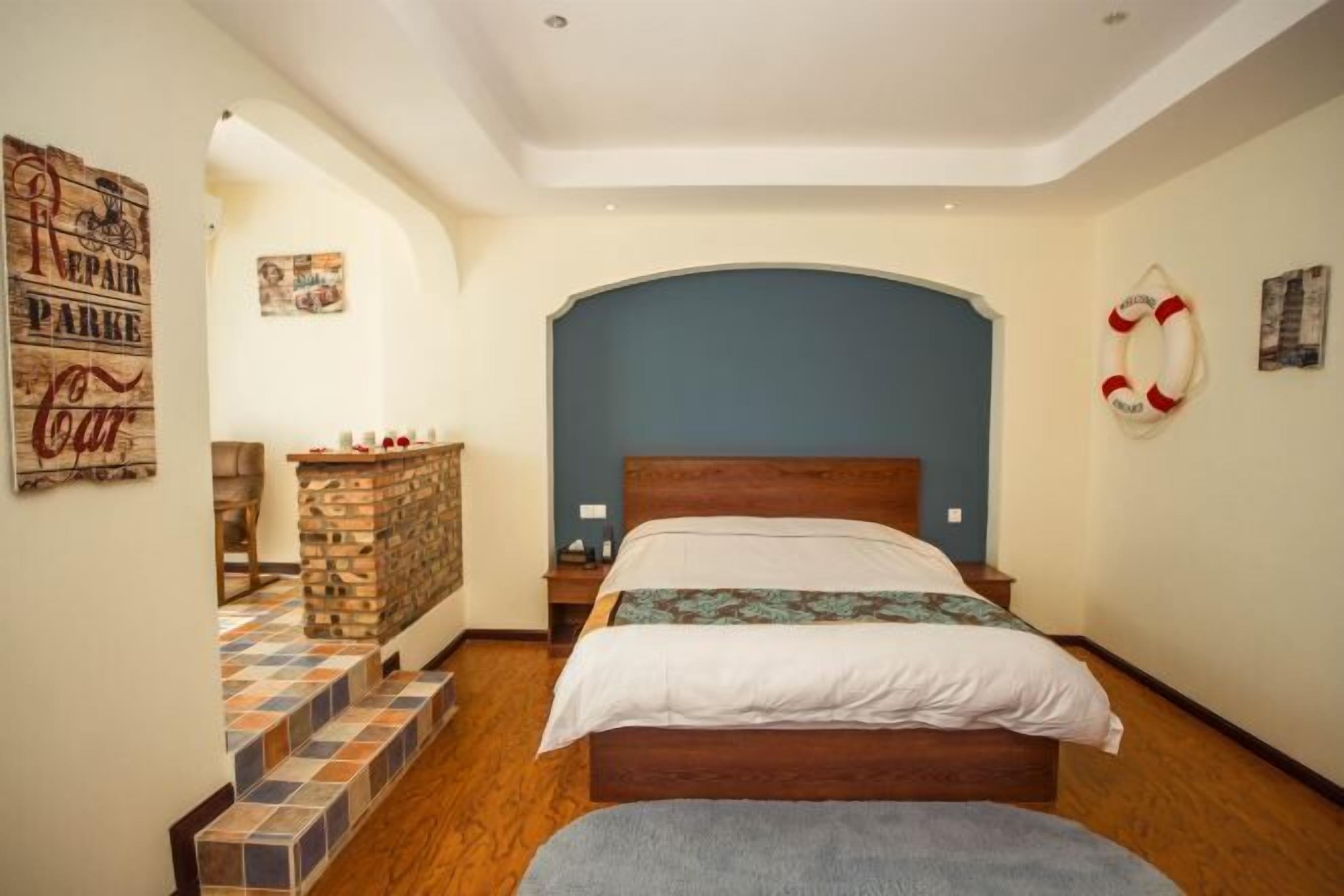 A bedroom with a wooden bed, a headboard, a small table, and a bench.