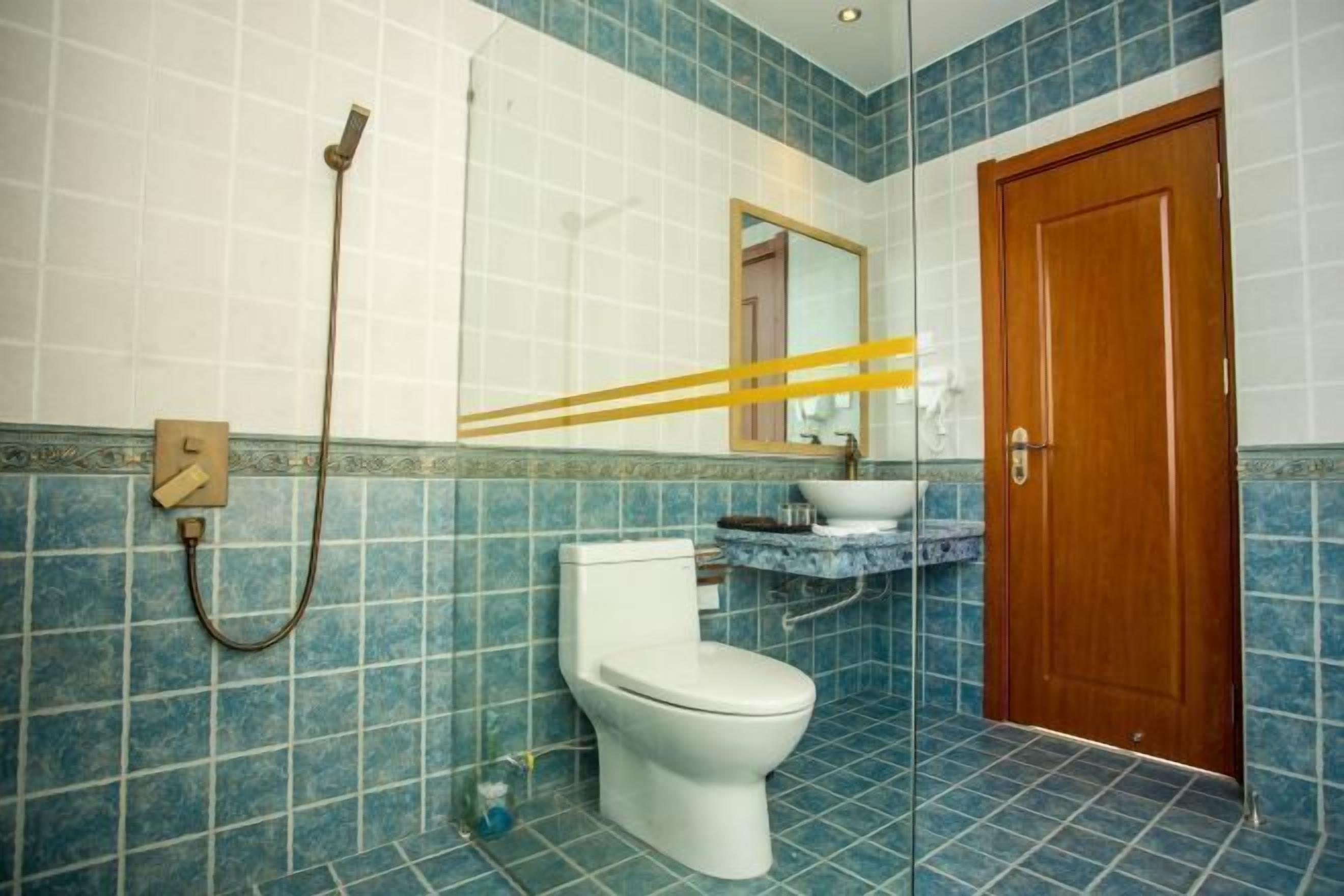 Ein Badezimmer mit Toilette, Waschbecken, Spiegel und Dusche.