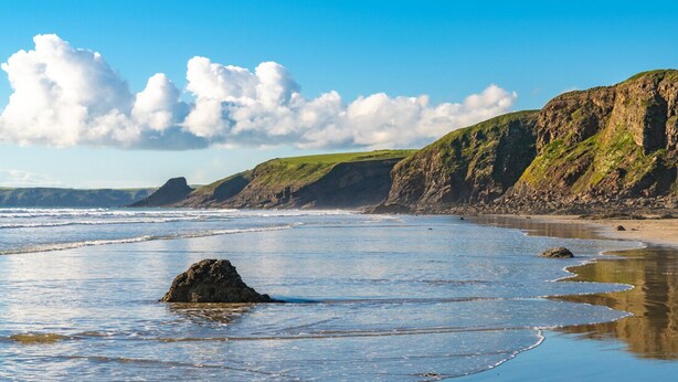 A coastal landscape with cliffs, a beach, and a large rock in the water. - Cwtch Cottage, Holiday Cottage Broad Haven, Sleeps 5, 3 bedrooms,  bathrooms (Haverfordwest)