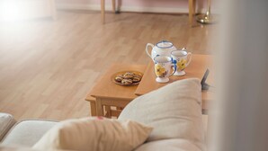 A cozy living room with a wooden coffee table, a plate of cookies, and a tea set. - Cwtch Cottage, Holiday Cottage Broad Haven, Sleeps 5, 3 bedrooms,  bathrooms (Haverfordwest)