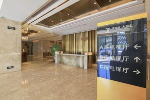 A hotel lobby with a reception desk, directional signs, and a modern interior design. - City Posthouse (Shenzhen Buji Daduhui) (Shenzhen)
