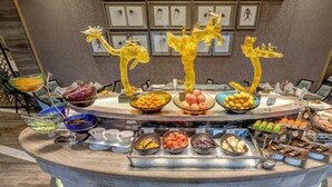 Un bufé con diferentes platillos y esculturas decorativas de jirafas.