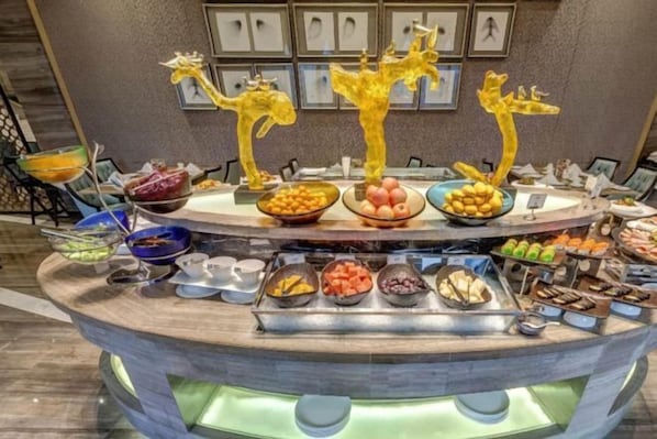 Un buffet proposant une variété de plats et agrémenté de sculptures de girafes décoratives.