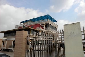 A two-story building with a balcony, a gated entrance, and a clear sky. - Jinze Farm House (Shanghai)