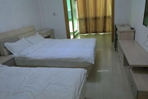A hotel room with two beds, a desk, and a TV. - Jinze Farm House (Shanghai)