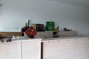A kitchen with a countertop, cabinets, and various kitchen items. - Jinze Farm House (Shanghai)