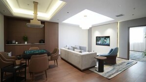 A modern living room with a sofa, a gaming table, and a television. - Chengcheng Huayuan Building (Chengcheng)