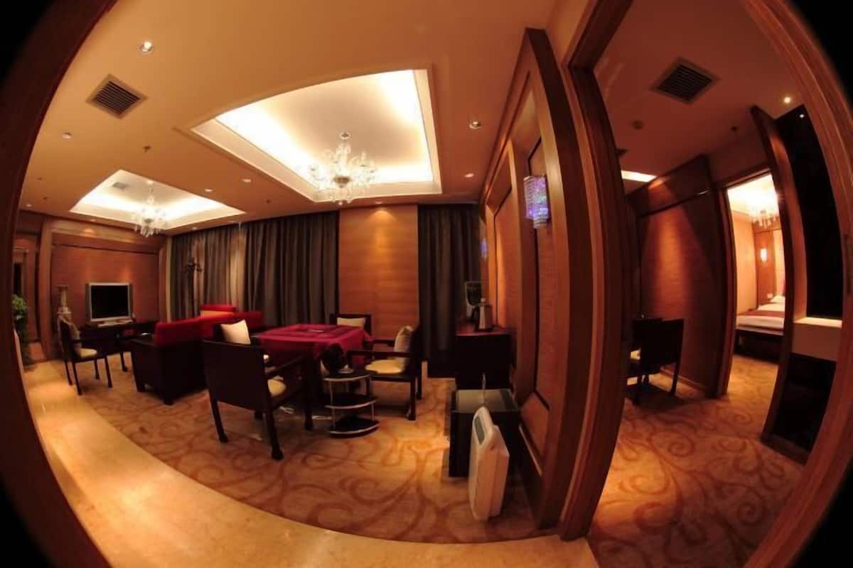 Ein Hotelzimmer mit gewölbter Decke, einem Chandelier, einem roten Sofa, einem Schreibtisch und einem Bett.