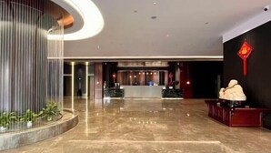 A spacious lobby with a marble floor, a reception desk, and a statue. - Chengcheng Huayuan Building (Chengcheng)